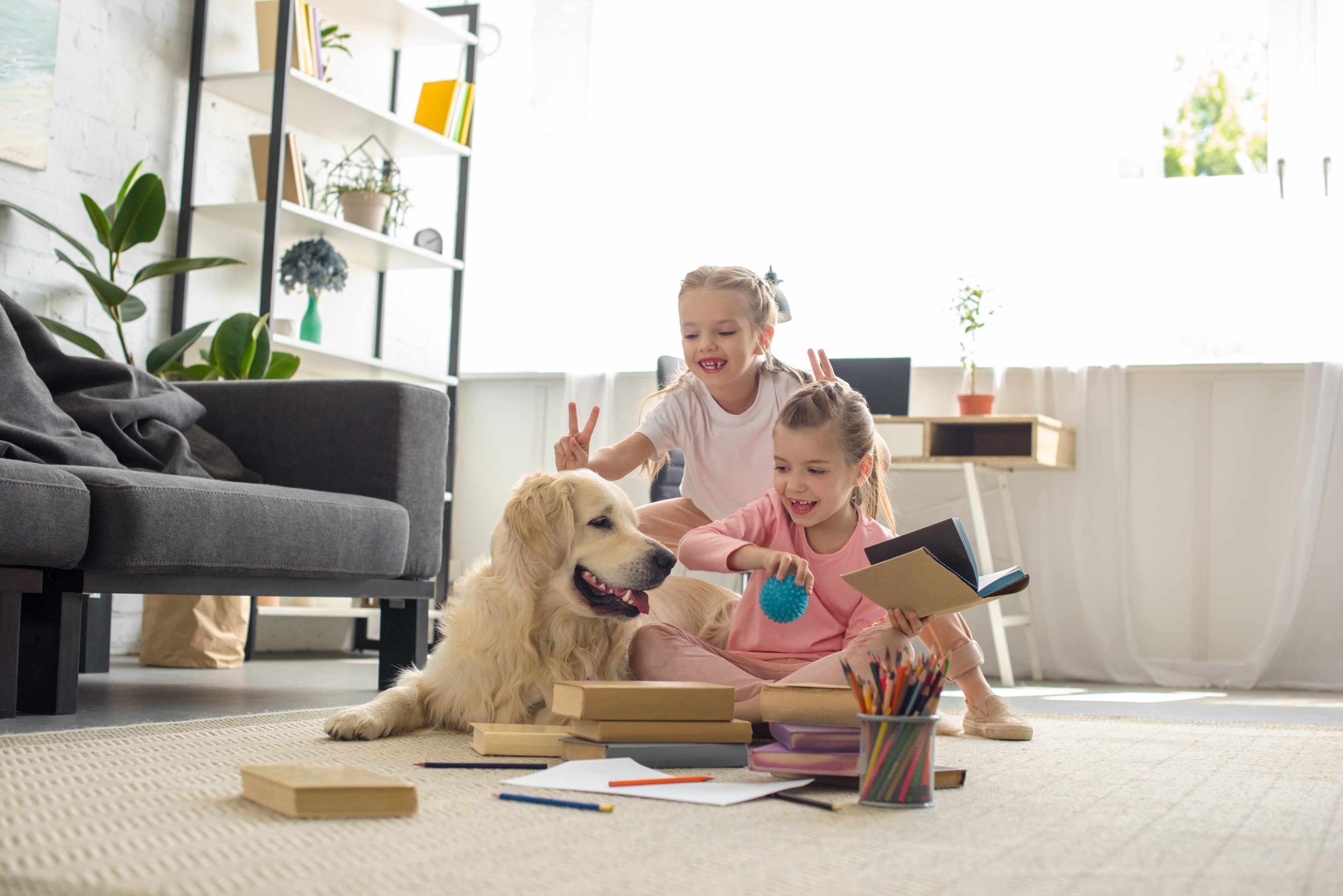 Children playing with dog in living room
